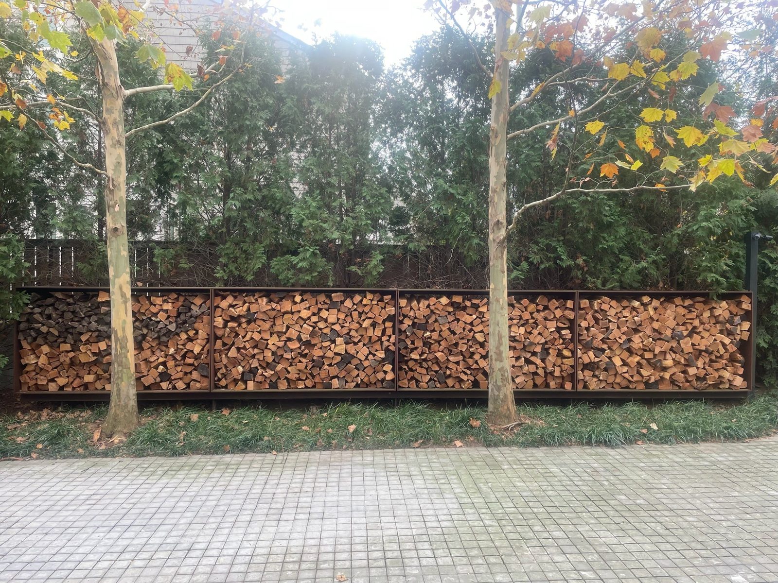 A long stack of firewood kept off the ground and dry